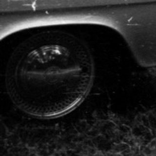 Vintage cars and tents at lakeside campsite.