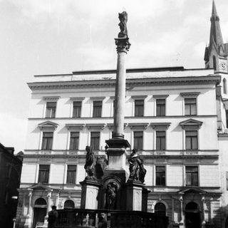Neoclassical monument with tall column and statues.
