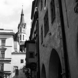 Historic European street with medieval architecture and church spire.