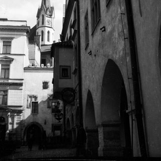 Historic European street with medieval architecture and church spire.