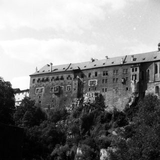 Historic castle perched on rocky riverbank.