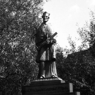 Statue of a robed figure holding an open book.