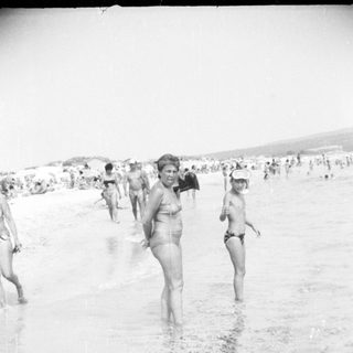 People swimming and wading in ocean.