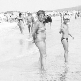 People swimming and wading in ocean.