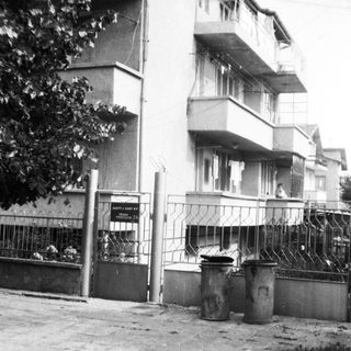 Urban residential building entrance with trash bins.