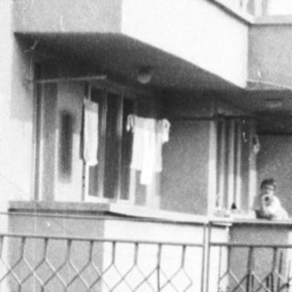 Urban residential building entrance with trash bins.