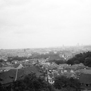 Historic cityscape with rooftops and distant skyline.