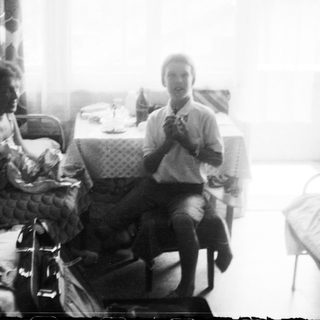 Two people sitting indoors with a cat.