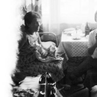 Two people sitting indoors with a cat.