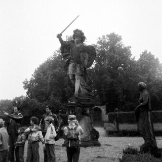 Statue of a warrior holding a sword in a park.