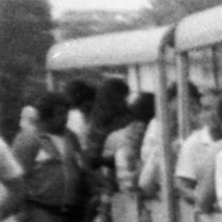 Vintage minibus parked with people boarding.