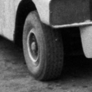 Vintage minibus parked with people boarding.