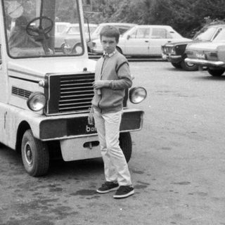 Vintage minibus parked with people boarding.