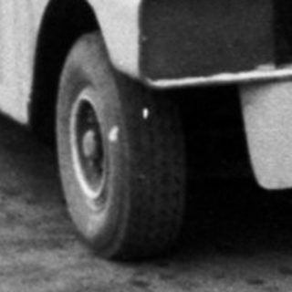 Small shuttle bus loading passengers in parking area.