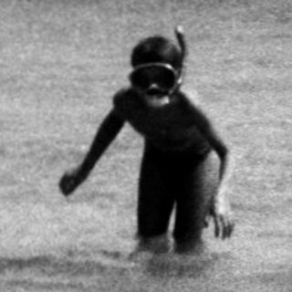 Children playing in shallow ocean waves.