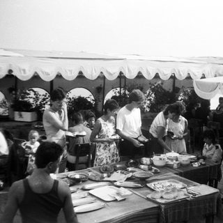 Outdoor buffet event with people serving food.