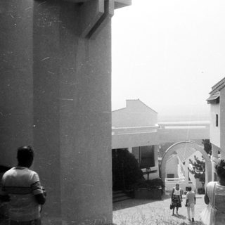 Group of people gathered near arched entrance.