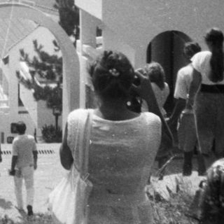 Group of people gathered near arched entrance.