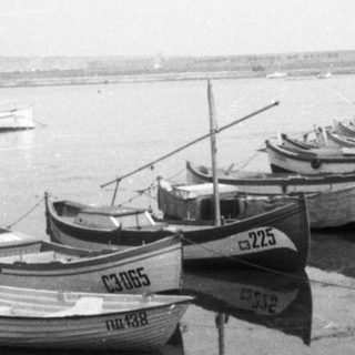 Small boats docked along a harbor pier.