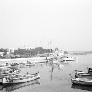 Small boats docked near a waterfront port area.