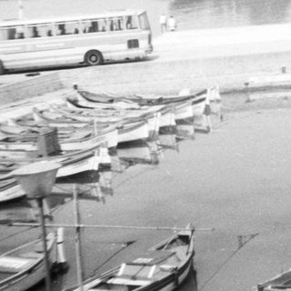 Boats docked along a misty riverbank.