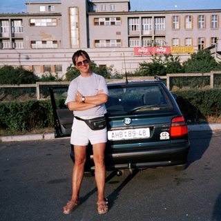 Person posing by vintage BMW car.
