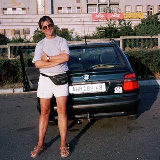 Person posing by vintage BMW car.