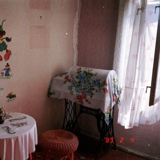 Vintage room with Disney characters mural, floral tablecloth, sewing machine.