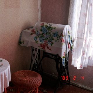 Vintage room with Disney characters mural, floral tablecloth, sewing machine.