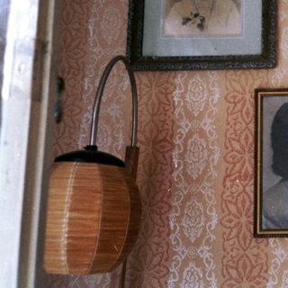 Vintage portraits in ornate frames on patterned wall.