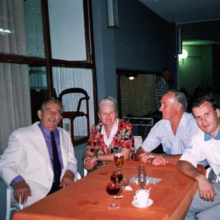 Four people dining together indoors at night.