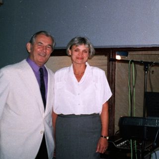 Three adults posing near a keyboard and digital clock.