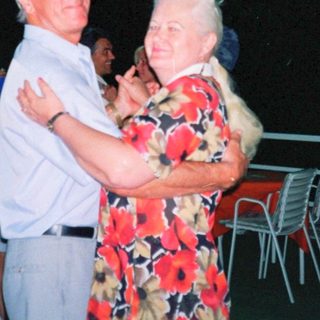 Couple dancing outdoors at night party.