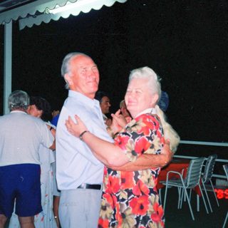 Couple dancing outdoors at night party.