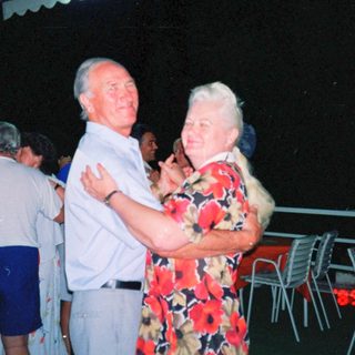 Couple dancing outdoors at night party.