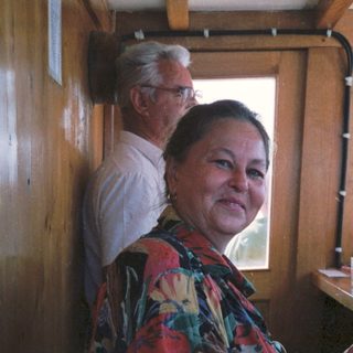 Two people in a vintage train cabin. Woman operating controls.