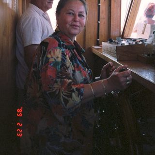 Two people in a wooden cabin, one cooking.
