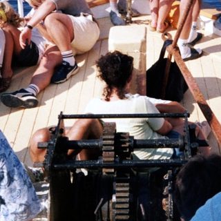 Group enjoying time on cruise ship deck by ocean.