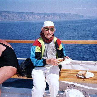 Man eating on cruise ship deck by ocean.