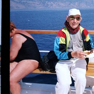 Man eating on cruise ship deck by ocean.