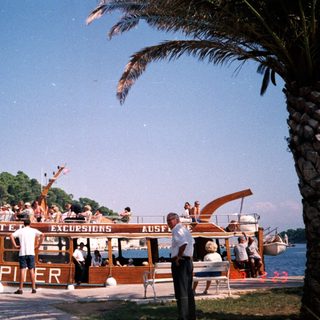 Boat named "Piter" offering excursions near coastal town.