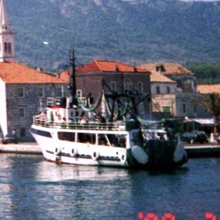 Coastal town with historic stone buildings and boats.