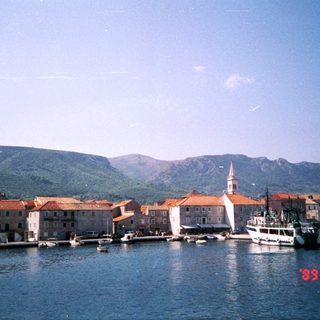 Coastal town with historic stone buildings and boats.