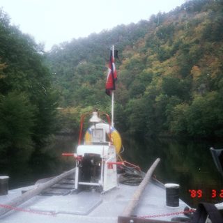 Ferry approaching docked vessel on river.