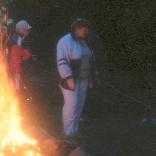 Group gathered around evening bonfire.