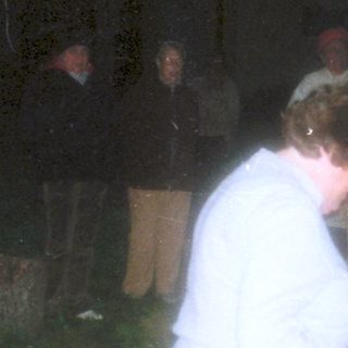 People gathered around a campfire at night.
