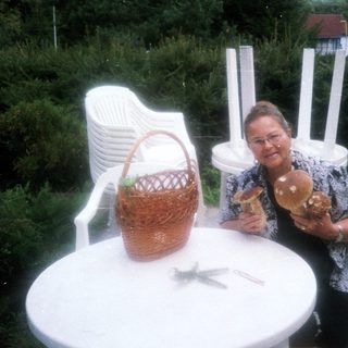 Woman sitting outside holding pastries near basket.