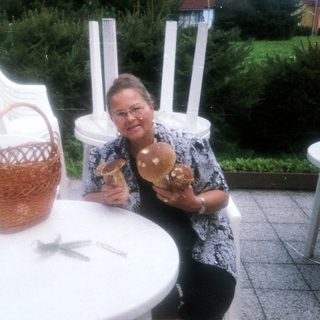 Woman sitting outside holding pastries near basket.