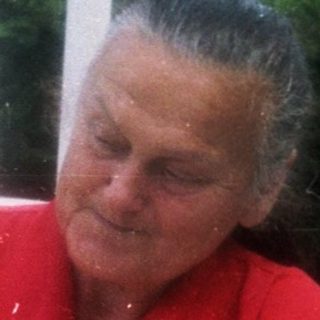 Woman tossing bread rolls outdoors.
