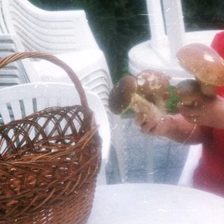 Woman tossing bread rolls outdoors.